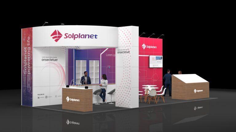 Modern exhibition stand featuring a front reception counter with stools, wall displays with digital screens, a small meeting area with a round table and chairs, and a sloped display structure, all arranged in an open, well-lit layout designed for visitor engagement.
