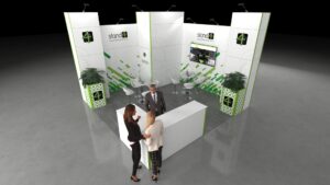 Open and inviting exhibition stand with an L-shaped reception counter and a central meeting area featuring two sets of tables and chairs. The structure is defined by large vertical columns, incorporates a large central TV screen, two curved planters, and a single lockable storage room.