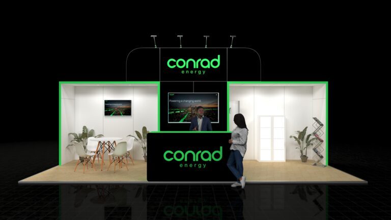 A large 8x3 metre exhibition stand. The stand features a central reception desk with a large screen above, a small meeting area with white furniture, and a brochure rack.